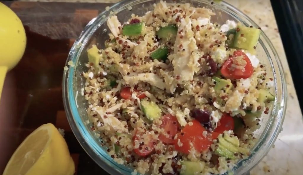 bowl of quinoa chicken salad sitting on a cutting board